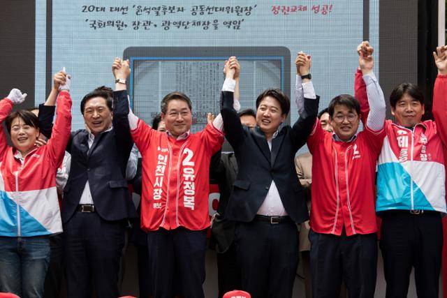 이준석(오른쪽 세 번째) 국민의힘 대표와 유정복(오른쪽 네 번째) 국민의힘 인천시장 후보를 비롯한 참석자들이 19일 인천 부평구 부평 문화의 거리에서 열린 ‘국민의힘 희망 인천 출정식’에서 손을 들어 보이고 있다. 뉴스1