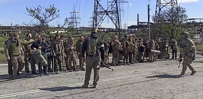 우크라 투항 군인들의 운명은 우크라이나 남부 항구도시 마리우폴의 마지막 항전 거점이었던 아조우스탈 제철소가 러시아군에 점령된 후 우크라이나 군인들이 17일(현지시간) 러시아군의 감시하에 이송될 준비를 하고 있다. 마리우폴 | EPA연합뉴스