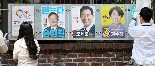 제8회 전국동시지방선거 공식 선거운동이 시작된 19일 서울 종로구 대학로에서 관계자들이 선거벽보를 부착하고 있다. /사진=이기범 기자leekb@