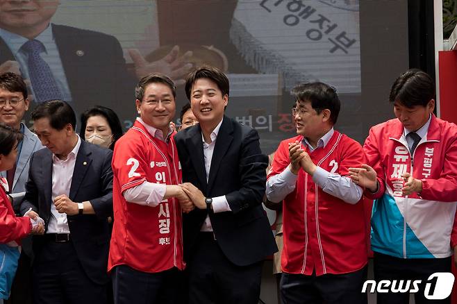 이준석 국민의힘 상임선대위원장과 유정복 인천시장 후보가 19일 인천시 부평구 부평 문화의 거리에서 열린 ‘국민의힘 희망 인천 출정식’에서 손을 맞잡고 있다. 2022.5.19/뉴스1 © News1 국회사진취재단