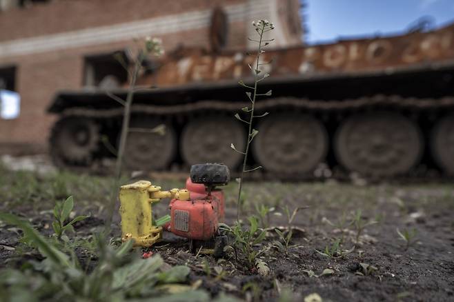 5월 16일 우크라이나 하르키우의 한 마을에 우크라이나군의 공격으로 파괴된 러시아군 탱크 잔해 옆에 어린이 장남감 하나가 놓여있다./UPI 연합뉴스