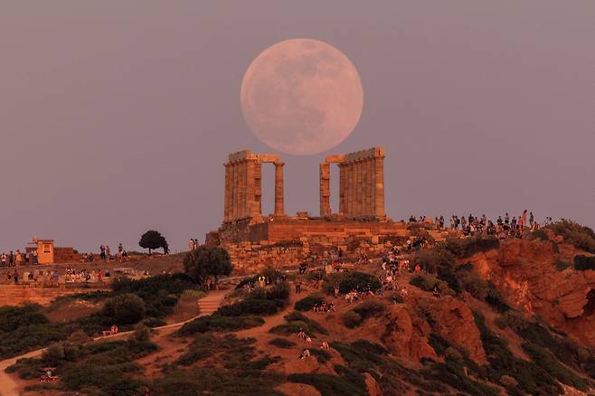 5월 15일 그리스 아테네 인근 케이프 소니온에서 사람들이 포세이돈 신전 위로 떠오르는 보름달을 구경하고 있다. 그리스에서는 이날 월식이 관측됐다./로이터 연합뉴스