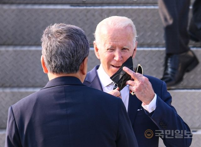 조 바이든 미국 대통령이 20일 경기도 오산 미 공군기지에 전용기인 에어포스원을 타고 도착해 마스크를 벗고 있다.