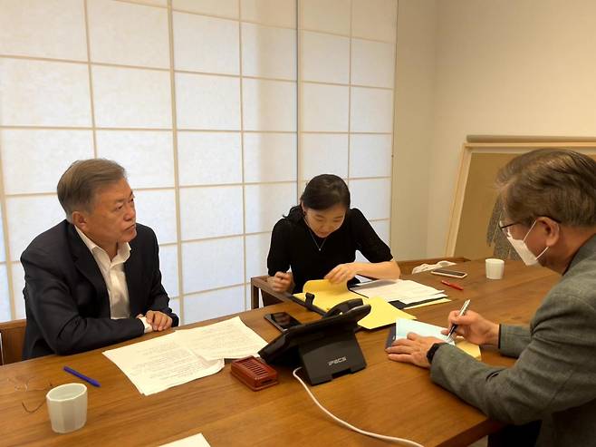 Former South Korean President Moon Jae-in (left) speaks with US President Joe Biden over the phone, at his home in Yangsan, South Gyeongsang Province on Saturday. (Yonhap)