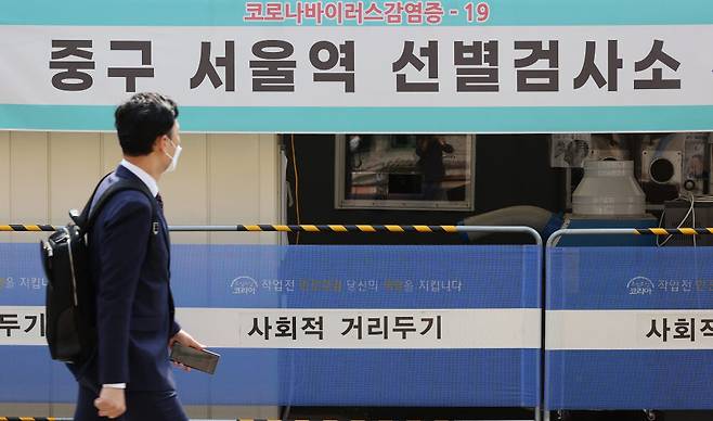 한 시민이 서울 중구 서울역 선별검사소를 지나치고 있다. <연합뉴스>