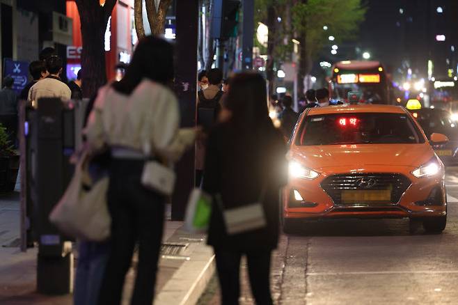 코로나19 방역을 위한 사회적 거리두기 전면 해제 후 자정을 넘긴 시간 서울 강남역 인근에서 시민들이 택시를 잡기 위해 서 있다. 오랜만에 늦은 시간까지 외부 활동을 즐기는 사람들이 늘면서 ‘택시 대란’이 벌어졌다.(사진=연합)