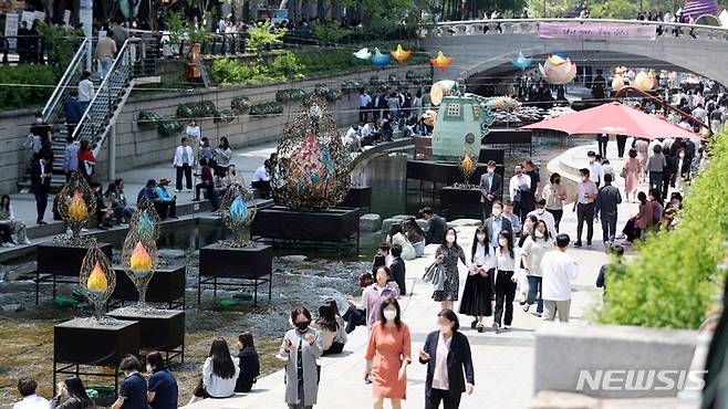 [서울=뉴시스] 추상철 기자 = 초여름 날씨를 보인 지난 4일 오후 서울 중구 청계천에서 점심식사를 마친 많은 직장인들이 휴식을 취하고 있다. 2022.05.04. scchoo@newsis.com