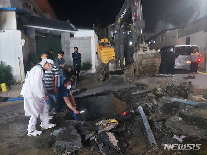 [제천=뉴시스] 안성수 기자 = 24일 오후 6시54분 충북 제천시 신백동 한 사거리 도로에서 수도관 파열로 지름 1m, 깊이 2m 크기의 싱크홀(땅 꺼짐 현상)이 발생해 제천시가 복구작업에 나서고 있다. 2022.05.24 photo@newsis.com