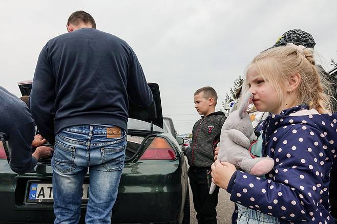지난 7일 오전 우크라이나 르비우 셰게니 국경검문소에서 마리아나의 가족들이 폴란드로 향하기 위해 차에 짐을 싣고 있다. /연합뉴스