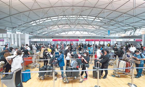 Tourists wait to depart from Terminal 1 of Incheon International Airport on Wednesday afternoon as the number of people going on vacations overseas has increased with the easing of quarantine and testing measures. [YONHAP]