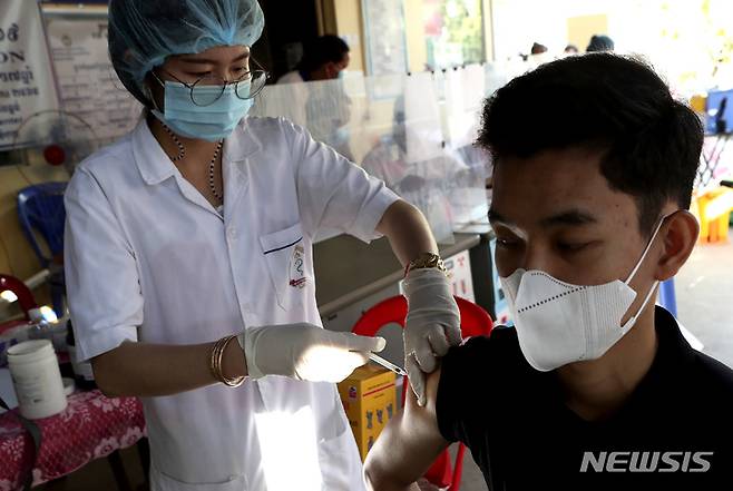 [프놈펜=AP/뉴시스] 14일(현지시간) 캄보디아 프놈펜의 한 건강센터에서 한 남성이 화이자 백신 4차 접종을 하고 있다. 캄보디아는 최근 오미크론 변이 감염 사례가 증가하면서 고위험군을 대상으로 코로나19 백신 4차 접종을 시작했다. 2022.01.14.