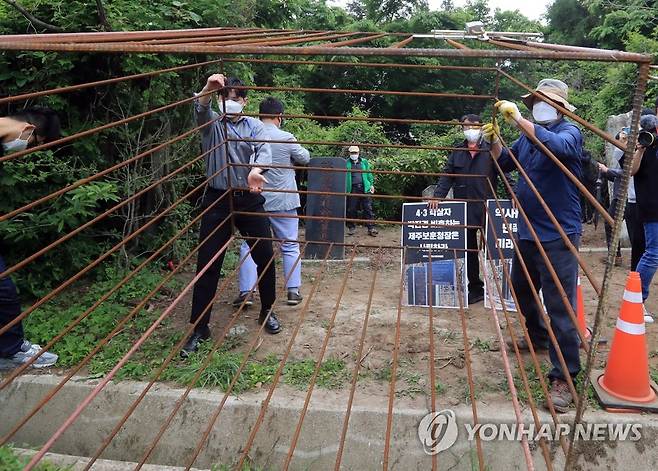 강제 철거되는 '역사의 감옥' (제주=연합뉴스) 백나용 기자 = 제주도 보훈청이 20일 오후 제주시 한울누리공원 인근 도로변에 있는 박진경 추도비에 설치됐던 감옥 형태 조형물을 철거하는 행정대집행을 진행하고 있다.
    앞서 제주지역 시민·사회단체들은 지난 3월 10일 제주 4·3 당시 무차별 진압을 주도해 학살 주범으로 평가받는 박진경 추도비에 단죄의 의미를 담아 이 조형물을 설치했다. 2022.5.20 dragon.me@yna.co.kr