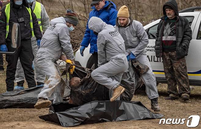 13일 (현지시간) 우크라이나 수도 키이우 인근 부차에서 러시아 군이 집단 매장한 민간인을 인부들이 수습을 하고 있다. © AFP=뉴스1 © News1 우동명 기자