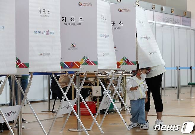 6.1동시지방선거 사전투표일인 27일 인천국제공항에 설치된 사전투표소에서 한 유권자가 아이와 함께 투표를 하고 있다. 2022.5.27/뉴스1 © News1 박세연 기자