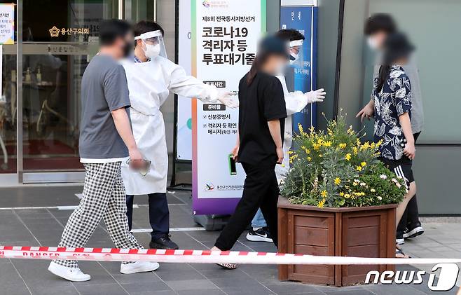 제8회 전국동시지방선거 사전 투표 이틑날인 28일 오후 서울 용산구의회에 마련된 이태원 제1동 사전투표소에서 신종 코로나바이러스 감염증(코로나19)에 확진된 유권자들이 소중한 한 표를 행사하기 위해 사무원들의 안내를 받고 있다. 확진자 투표 시간은 이날 오후 6시 30분부터 오후 8시까지로, 투표 마감시간 전까지만 사전투표소에 도착하면 투표에 참여할 수 있다. 2022.5.28/뉴스1 © News1 구윤성 기자