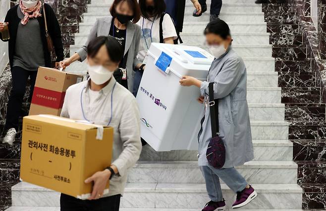 제8회 전국동시지방선거 사전투표 이틀째인 28일 서울 용산구의회에 마련된 사전투표소에서 관계자들이 관내 투표함과 관외사전 회송용봉투를 옮기고 있다. /연합뉴스