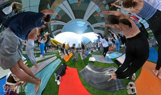 21일 서울 여의도 잔디광장에서 300여명의 요가인들이 '형형색색'의 매트위에서 '108 수리야 나마스카라(시퀀스)'를 하며 우크라이나의 평화와 자유를 기원하고 있다.