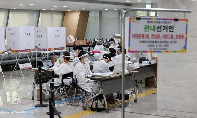제8회 전국동시지방선거 사전투표 이틀째인 28일 서울 용산구의회에 마련된 사전투표소에서 투표사무원과 관계자들이 코로나19 확진·격리자 사전투표를 위해 방호복 등을 착용한 후 대기하고 있다. [연합]