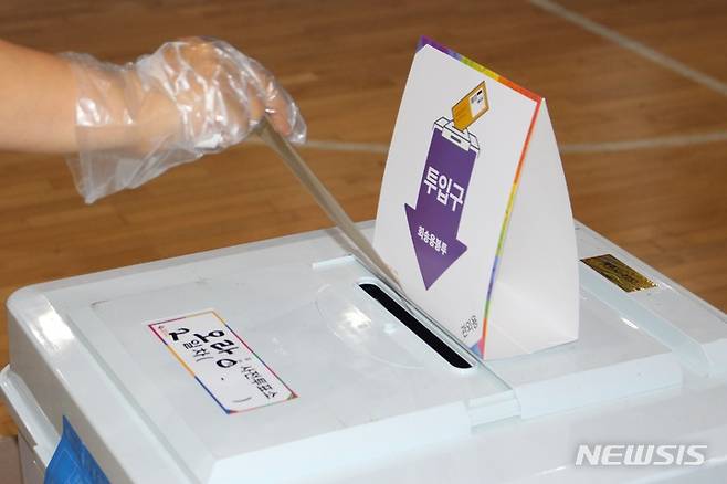 [제주=뉴시스] 양영전 기자 = 제8회 전국동시지방선거 사전투표 이틀째인 28일 오후 제주시 오라동 사전투표소가 마련된 한라체육관 보조경기장을 찾은 한 유권자가 비닐장갑을 착용한 채 투표용지를 담고 있다. 2022.05.28. 0jeoni@newsis.com