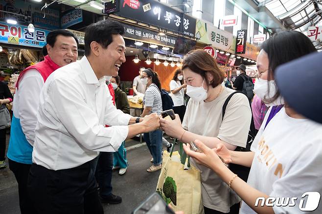 오세훈 국민의힘 서울시장 후보가 지난 27일 서울 강북구 수유시장을 찾아 시민들과 인사하며 지지를 호소하고 있다. /뉴스1 © News1 유승관 기자