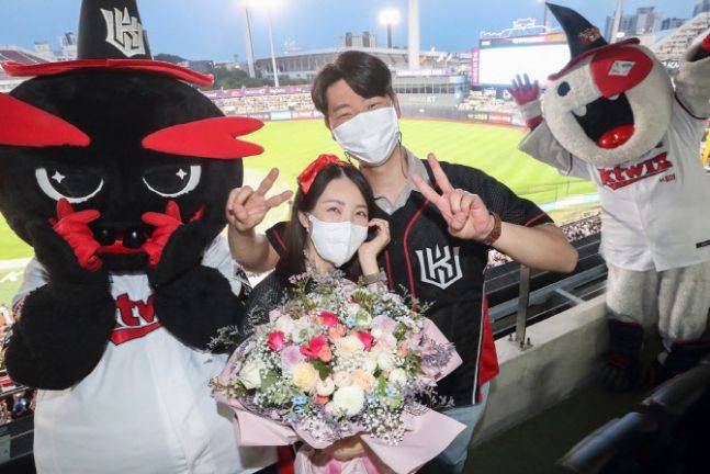 28일 수원 KT 위즈파크 홈경기에서 KT 위즈 팬 유경진씨가 프로포즈 후 KT 위즈의 마스코트(빅, 또리)와 함께 기념 촬영을 하는 모습./ KT 제공