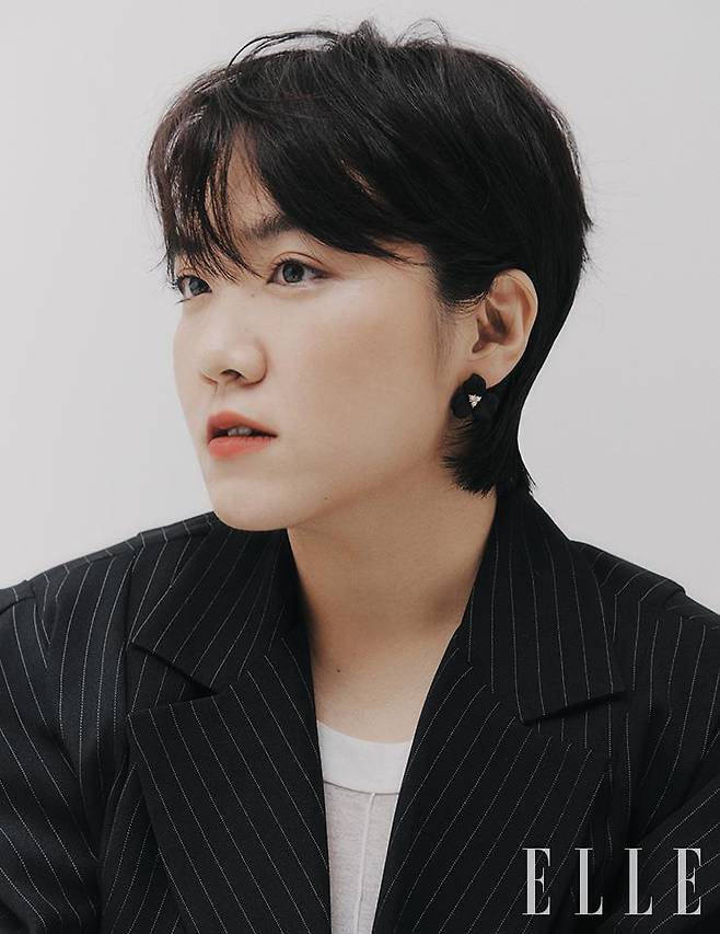 김수정이 입은 스트라이프 수트 세트업은 Dint. 슬리브리스 톱은 Whole Paper. 이어링은 Danaburton.