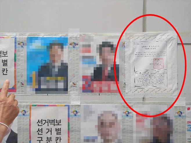 부산 동래구청장 후보자 벽보 위에 선거공고문(빨간 원)이 덧붙여진 모습. 부산경찰청 제공
