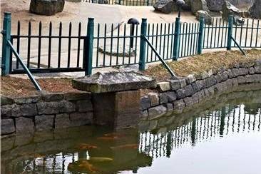 ▲사진3. 돌 비석처럼 생긴 7세기 월지의 배수구. 다섯 개의 배수 구멍이 뚫려있다. 물과 맞닿은 곳에 구멍이 슬쩍 드러나 있고 새로 연결된 현대식 배수구 길이 지표면에 보인다. ⓒ이순희