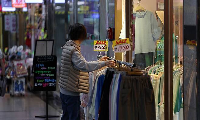 29일 오후 서울 명동 인근 지하상가 한 옷 가게에서 상인이 옷을 진열하고 있다. 연합뉴스