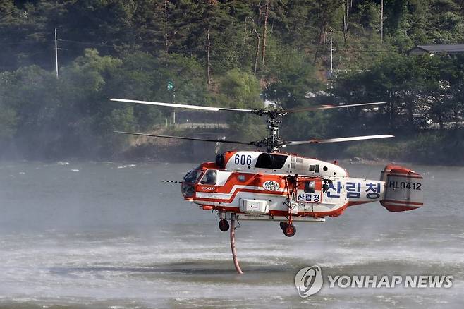 쉴 틈 없는 헬기 (울진=연합뉴스) 손대성 기자 = 29일 오전 경북 울진군 근남면 일원에서 산불이 번지자 산불진화헬기가 불을 끄기 위해 물을 채우고 있다. 2022.5.29 sds123@yna.co.kr