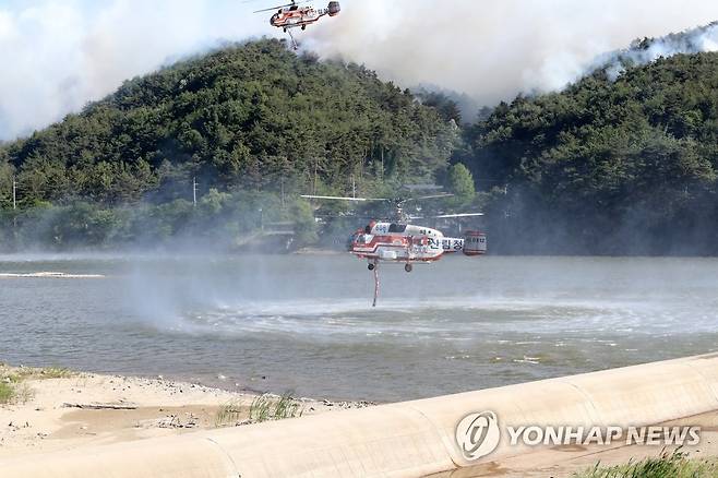 담수하는 헬기 (울진=연합뉴스) 손대성 기자 = 29일 오전 경북 울진군 근남면 일원에서 산불이 번지자 산불진화헬기가 불을 끄기 위해 물을 채우고 있다. 2022.5.29 sds123@yna.co.kr