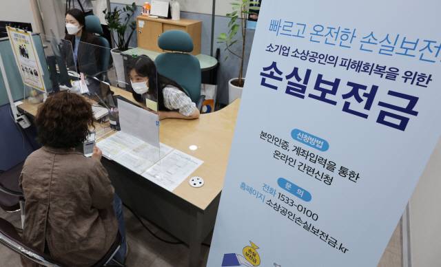 ▲ 신종 코로나바이러스 감염증(코로나19) 방역 조치로 피해를 입은 소상공인·자영업자들은 이르면 30일 오후부터 최대 1000만원의 손실보전금을 받을 수 있다. 이날 오전  서울 종로구 소상공인시장진흥공단 서울중부센터에서 자영업자가 소상공인 손실보전금 관련 상담을 받고 있다. 연합뉴스,