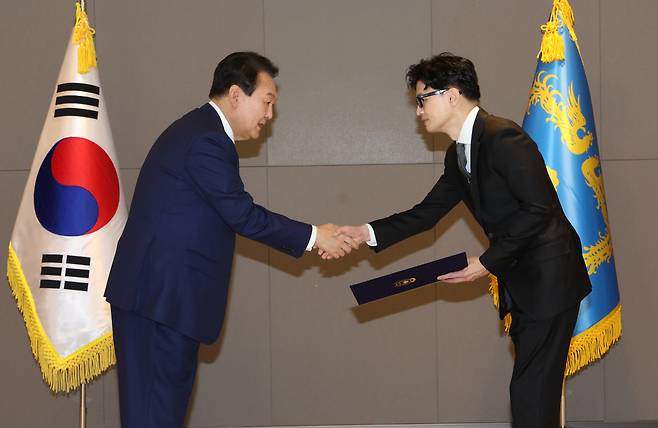 President Yoon Suk-yeol (left) shakes hands with Justice Minister Han Dong-hoon during the appointment ceremony held May 26. (Yonhap)