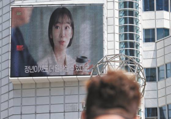 합리적인 이유 없이 연령만을 이유로 직원의 임금을 깎는 '임금피크제'는 고령자고용법을 위반한 것이므로 무효라고 26일 대법원의 판결했다. 사진은 이날 서울 중구 서울고용노동청 외벽 모니터의 고령자 계속 고용장려금 광고. 연합뉴스