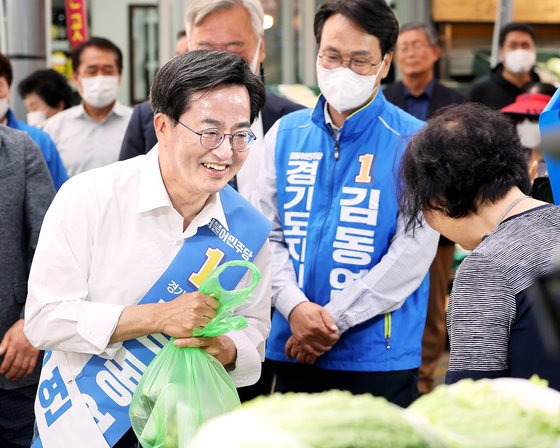 더불어민주당 김동연 경기도지사 후보가 31일 오전 경기도 오산시 오색시장을 방문해 채소를 사고 있다. 연합뉴스