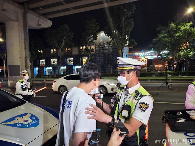 30일 밤 11시30분쯤 서울 광진구 아차산로 일대에서 헬멧을 쓰지 않고 음주 상태로 전동킥보드를 타던 20대 남성이 단속에 걸려 음주측정기를 불고 있다. /사진=박수현 기자