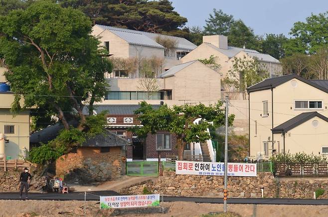 [양산=뉴시스] 안지율 기자 = 24일 오후 경남 양산시 하북면 평산마을 문재인 전 대통령 사저 앞 도로에 보수단체가 진행하는 집회 소음으로 인한 주민 생활 불편을 호소하는 현수막이 걸려 있다. 2022.5.24.