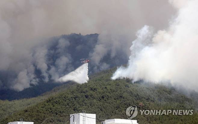 밀양 부북면 산불 '진화 작업' (밀양=연합뉴스) 김동민 기자 = 31일 오후 경남 밀양시 부북면 춘화리에서 발생한 산불이 바람을 타고 확산하고 있다. 
    산림청 헬기가 진화하는 모습. 2022.5.31 image@yna.co.kr