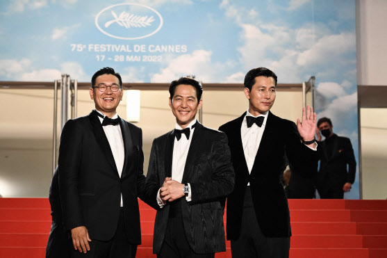 영화 ‘헌트’에 출연한 이정재(가운데), 정우성(오른쪽)이 19일(현지시간) 프랑스 남부 칸에서 열린 제75회 칸 국제영화제에서 손을 흔들고 있다. (사진=AFP)