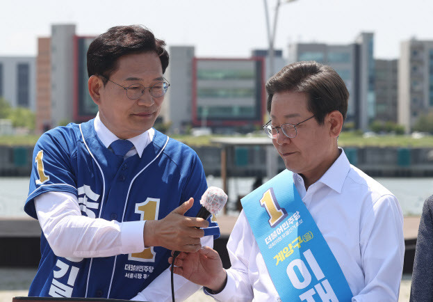 송영길 더불어민주당 서울시장 후보가 지난달 27일 경기 김포시 고촌읍 아라 김포여객터미널 아라마린센터 앞 수변광장에서 열린 `김포공항 이전 수도권 서부 대개발 정책 협약식`에서 이재명 인천 계양을 국회의원 보궐선거 후보에게 마이크를 건네고 있다. (사진= 국회사진기자단)