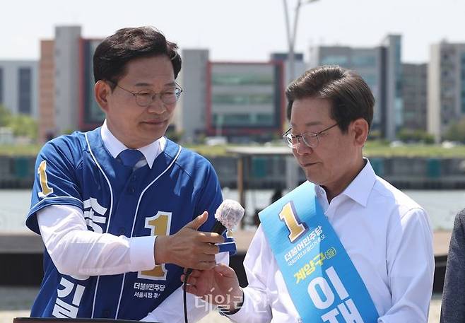 송영길 더불어민주당 서울시장 후보가 지난 27일 김포시 고촌읍 아라 김포여객터미널 아라마린센터 앞 수변광장에서 열린 김포공항 이전 수도권 서부 대개발 정책협약 기자회견에서 이재명 인천 계양을 국회의원 후보에게 마이크를 넘기고 있다. ⓒ국회사진취재단