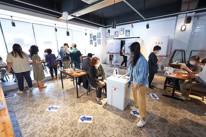 제8회 전국동시지방선거일인 1일 오전 서울 서대문구의 커피숍에 마련된 투표소를 찾은 유권자들이 투표하고 있다. <연합뉴스>