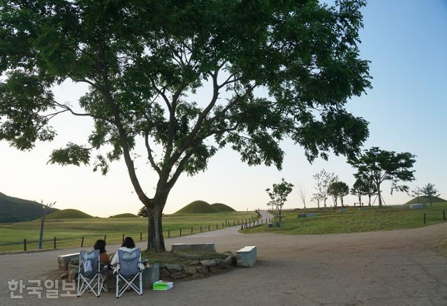 의성 조문국사적지 나무 그늘에서 여행객이 의자를 펴고 쉬고 있다. 소풍처럼 가볍게 쉬어가기 좋은 곳이다.