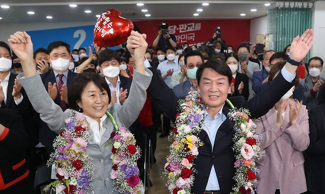 경기 성남 분당갑 국회의원 보궐선거에 출마한 안철수 국민의힘 후보가 1일 오후 당선이 확실시 되자 분당 선거사무소에서 부인 김미경씨와 함께 꽃을 받아들고 세리머니를 하고 있다. [연합]