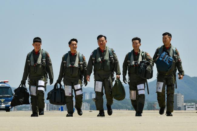 원인철 합참의장(가운데)이 5월31일 공군11전투비행단에서 F-15K 지휘비행을 마친 뒤 임무 수행 요원들을 격려하며 복귀하고 있다.(합참 제공)© 뉴스1