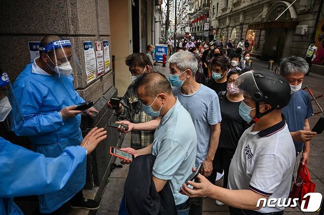 1일 (현지시간) 두달만에 코로나19 봉쇄령이 해제된 중국 상하이 황푸 지구 쇼핑물에서 방역요원이 주민의 QR 코드를 확인하고 있다. © AFP=뉴스1 © News1 우동명 기자