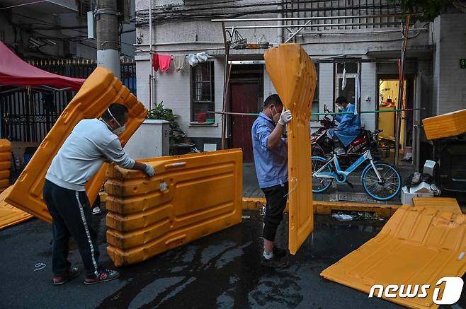 31일(현지시간) 코로나19 봉쇄령 해제를 앞두고 중국 상하이의 통제 구역 펜스를 인부들이 철거를 하고 있다. © AFP=뉴스1 © News1 우동명 기자
