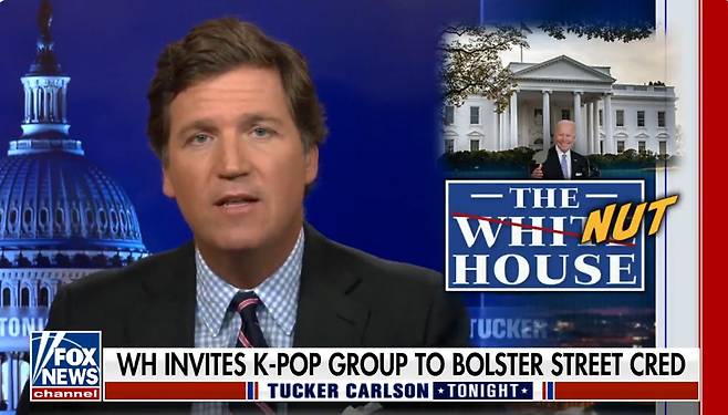 미국 폭스뉴스 진행자인 터커 칼슨이 BTS가 지난달 31일 백악관을 찾아 반아시안 증오범죄 대응 방안을 논의한 것과 관련해 백악관 'THE WHITE HOUSE'을 정신병원을 뜻하는 'NUT HOUSE'라고 쓴 배경화면속에서  조롱성 발언을 하고 있다./트위터