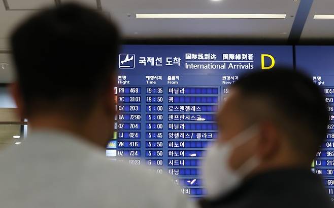 인천국제공항 입국장 전광판에 적혀있는 국제선 도착시간을 보고 있는 승객들의 모습이다. 연합뉴스 제공