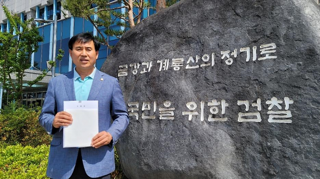 나인찬 청양군의회 부의장이 김돈곤 군수 고발장을 대전지방검찰청 공주지청앞에서 펼쳐 보이고 있다. 